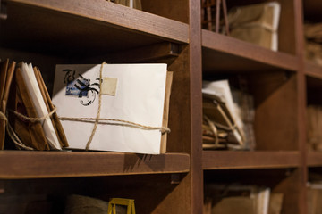 Stack of old letters on a wooden bookcase. Old mail of the post office