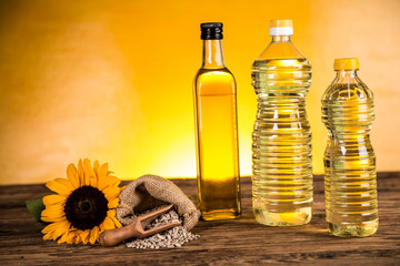 Sunflower oil in a bottle and sunflower flowers and sunflower seeds in a sack