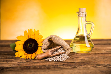 Sunflower oil in a bottle and sunflower flowers and sunflower seeds in a sack