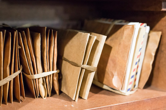 Stack of old letters on a wooden bookcase. Old mail of the post office