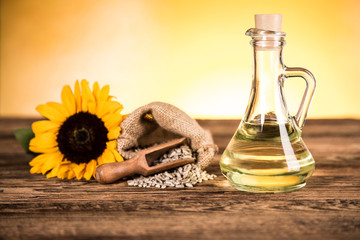 Sunflower oil in a bottle and sunflower flowers and sunflower seeds in a sack