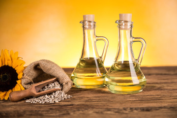 Sunflower oil in a bottle and sunflower flowers and sunflower seeds in a sack