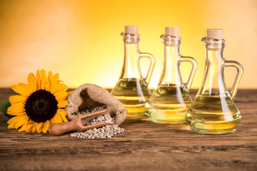 Obraz na płótnie Canvas Sunflower oil in a bottle and sunflower flowers and sunflower seeds in a sack