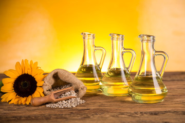 Sunflower oil in a bottle and sunflower flowers and sunflower seeds in a sack