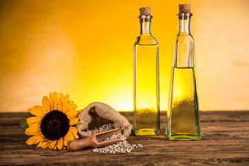 Sunflower oil in a bottle and sunflower flowers and sunflower seeds in a sack