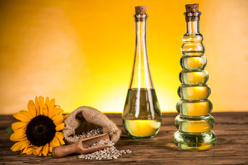 Sunflower oil in a bottle and sunflower flowers and sunflower seeds in a sack
