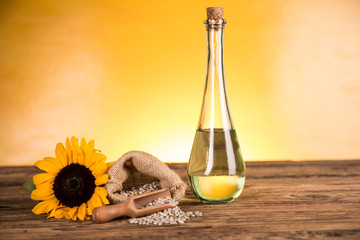 Sunflower oil in a bottle and sunflower flowers and sunflower seeds in a sack
