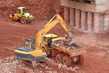 digger loading a dump truck on a road construction site