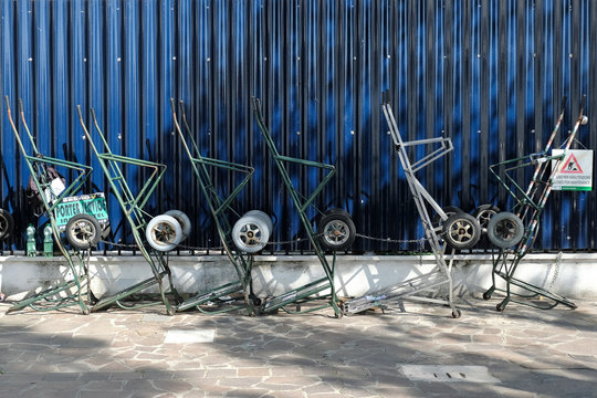 parters' hand carts standing next to a dark blue fence in Venice, Italy