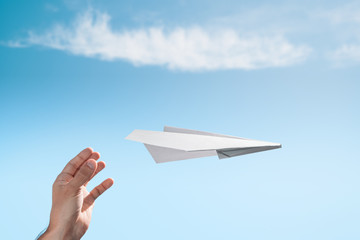 The launch of a paper plane in free flight. Male hand.