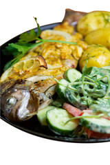 Baked trout on a plate with a salad of arugula, tomatoes, cucumbers and young potatoes with dill isolated on white background