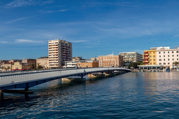 People cross the city bridge in Jazine bay in the town Zadar on a sunny day, Croatia