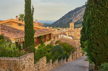 Fototapeta na wymiar View At carrer del Calvari With Typical Old Houses And City Center Pollença, old village on the island Palma Mallorca, Spain