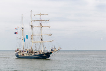 Fototapeta na wymiar Antique tall ship, vessel entering the harbor of The Hague, Scheveningen under a sunny and blue sky
