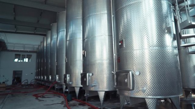 Large stainless steel wine distilling tanks. Silos for wine and beer fermentation . Steel barrels for fermentation of wine in winemaker factory .