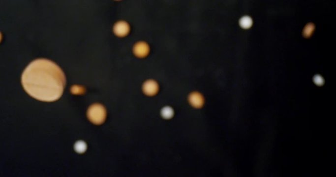 Closeup shoot of medical pills being dropped with background isolated on black