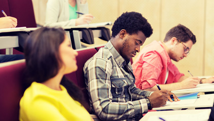 education, high school, university, learning and people concept - group of international students in lecture hall