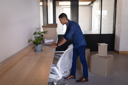 Businessman using laptop at desk in new office