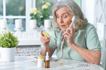 Portrait of sick senior woman sitting at table