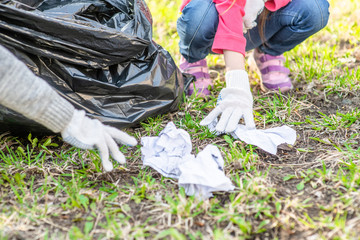 Close up group of children pick up trash in the park. Volunteer and ecology concept