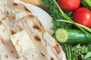 Summer food. Fresh tomatoes, cheese, cucumbers and lavash bread.