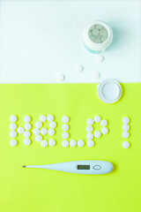 Pills in a shape of a word Help on a yellow background. Flat lay, top view, minimalistic style.