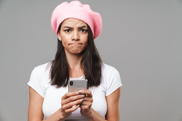 Attractive young brunette woman wearing beret standing