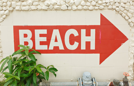 Red pointer on the beach. Direction arrows on the beach.