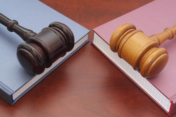 Different court decisions theme, two wooden books with judge gavels on table