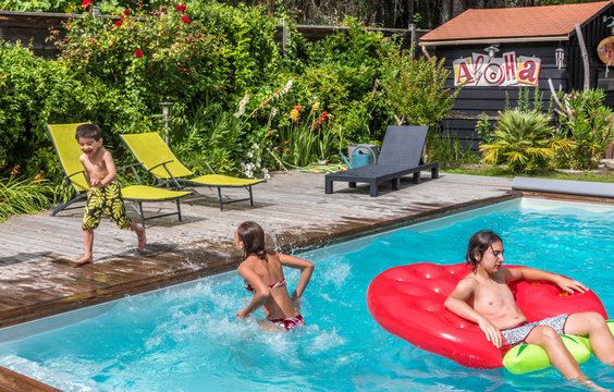 12-year-old girl and two boys of 6 and 14 years old playing in the swimming pool