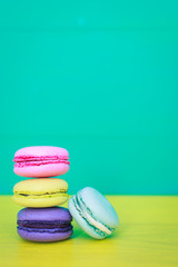 multicolored macarons on yellow-blue background