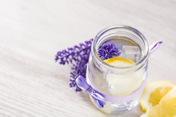 Lavender lemonade drink on white wooden table. Copyspace