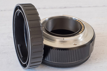 camera lens Extention Tube and End Cap on a White Painted Board