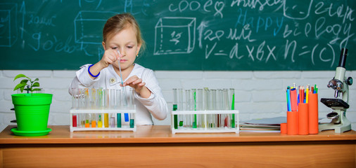 Girl cute pupil play with test tubes and colorful liquids. School chemical experiment. School education. Interesting approach to learn. Kid like to experiment. Explore and investigate. School lesson