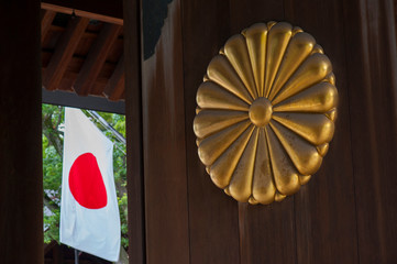 Modern japanese flag beside old gilded temple's doors, Yasukuni, Tokyo, Japan