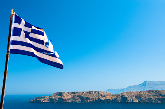Greek national flag before landscape of Egee sea, Gramvousa, Creta, Greece