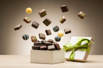 mix of chocolates jumping from gift box - obrazy, fototapety, plakaty