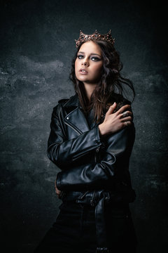 Young woman wearing a crown, a leather jacket, a hand on the shoulder