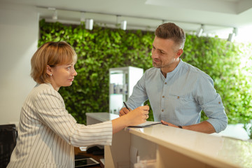 Administrator wearing striped jacket talking to constant client