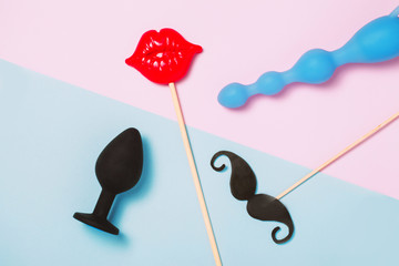 Adult sex toys and accessories on pink background.