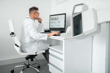 Obraz premium Professional plastic surgeon sitting at the computer while working