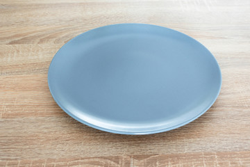 Empty gray plate on wooden table