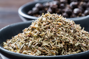 Dried Rosemary herb in black bowl close up macro