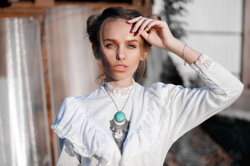 Close-up portrait of a girl in a white dress with a necklace in retro style