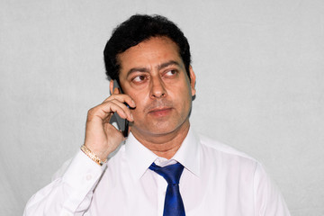 Happy businessman talking on mobile phone , studio shot on white background.