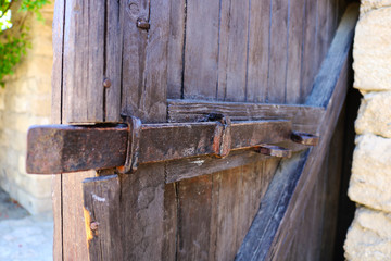 Old vintage wooden door with lock and latch. Old wooden door with rusty fastening. 