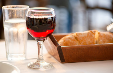 Wasser, Rotwein und Brot, Abendessen im Hafen in tiefstehendem Sonnenlicht
