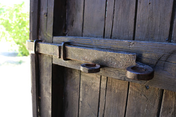 Old vintage wooden door with lock and latch. Old wooden door with rusty fastening. 