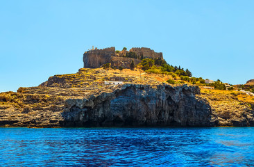 view of mountain and fortress of Lindos from the sea Castle of St. John in Lindos, Rhodes Island, Greece