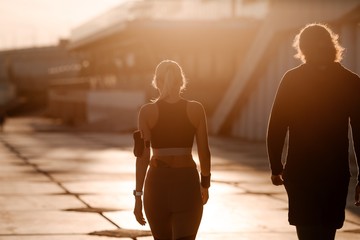Happy couple walking outdoors osveshenie sunlight. Morning jog on the waterfront. Family leads a healthy lifestyle